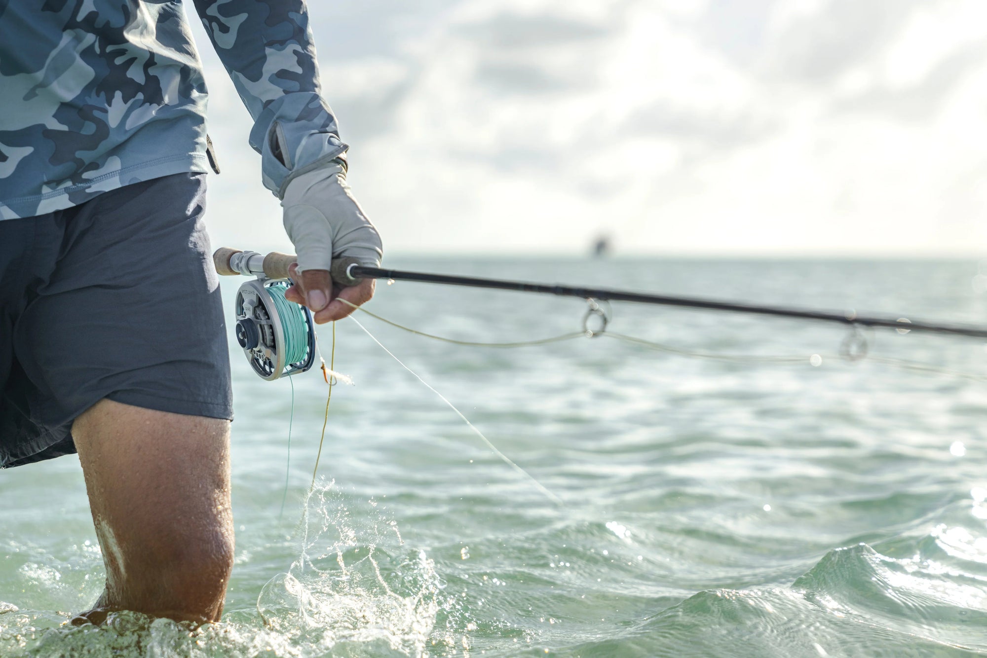Person fishing in water with a rod and reel